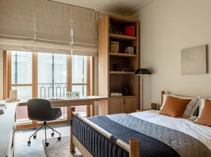 A modern bedroom featuring a wooden bed and shelves.