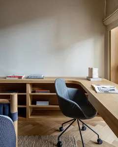 A modern office setting with a wooden desk and a black office chair.
