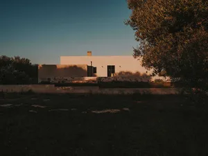 A modern residential exterior featuring concrete and stone materials.