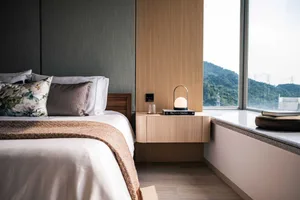 Modern bedroom interior with wooden accents and fabric bedding.