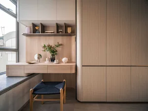 A modern vanity table with wooden design features, including a floating shelf, drawers, and a bench with woven seat.