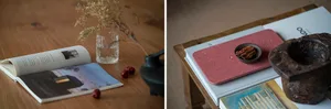 A wooden coffee table with a glass of water, dried fruits, a book, and decorative items.