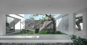 Modern interior with a view of a garden through a concrete porch, featuring minimalistic design elements.