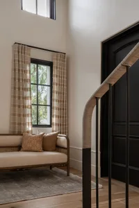 A modern living room with natural fiber curtains and woven cane furniture.