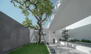 A minimalist residential home entrance featuring concrete and stone materials.