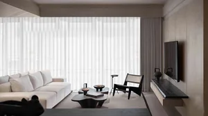 Minimalist living room featuring textured fabric curtains and a modern sofa.