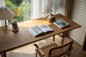 A modern interior workspace featuring a wooden desk with books, magazines, and a lamp.