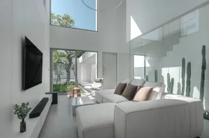 Modern living room featuring glass walls, concrete flooring, and minimalist furniture.