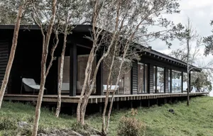 A modern residential exterior with wooden siding and large windows.