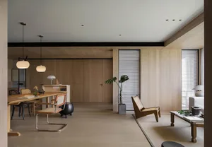 A minimalist living room with wooden furniture and a potted plant.