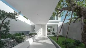 現代簡約建築設計的入口，搭配混凝土牆面與大型玻璃窗。