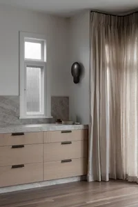Modern bathroom featuring storage space with marble surface and concrete accents.