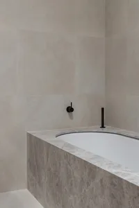 Modern minimalist bathroom featuring marble elements and a freestanding bathtub
