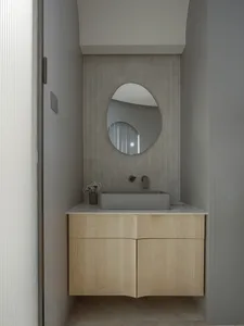 Minimalist bathroom with concrete walls and a modern square sink on a wooden vanity.