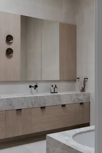 Modern minimalist bathroom featuring marble finishes and sleek design elements.