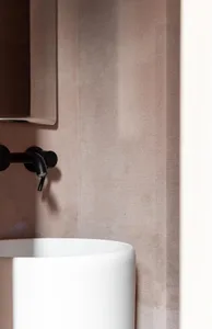 Modern bathroom featuring a minimalist, concrete sink with sleek black faucet.