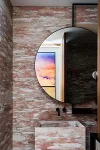 Modern bathroom featuring marble walls and countertop.