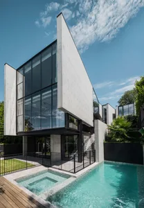 Modern house with concrete exterior and large glass windows.