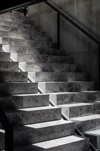 Modern, sleek staircase made of gray concrete with a geometric design.