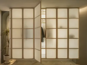 Modern interior design featuring a glass-paneled wardrobe with brown wooden accents.