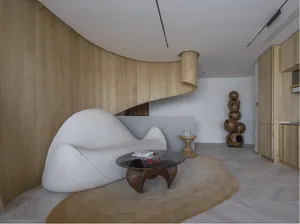 A modern living room with a white curved sofa and wooden paneling.