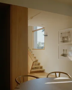 Modern interior with wooden staircase, large window, and minimalist design