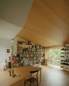 A modern library with wooden shelves filled with books.