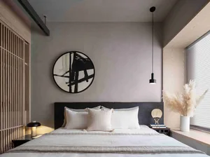 Modern, minimalist bedroom featuring white bedding, black headboard, and textured white pillows, with a black pendant light a