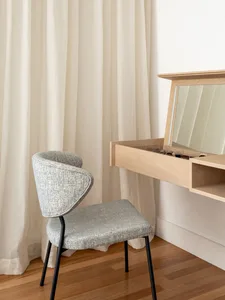 A modern minimalist dresser made of wood with a mirror and drawer.