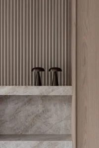 Modern minimalist room with a marble shelf topped with two industrial-style table lamps.