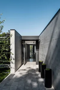 Modern entrance with concrete walls and black metal accents.