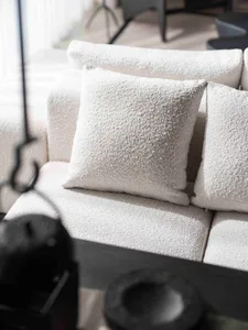 A modern home decor scene showcasing a textured fabric couch with square pillows.