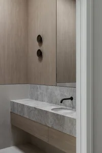 Modern bathroom with marble countertop and floating cabinet.