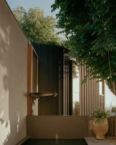 Modern minimalist design featuring a black metal exterior with vertical slats and a small pool area.