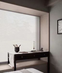 A minimalist bedroom scene with white blinds covering a window, a dark wooden table, and a framed abstract painting on the wa
