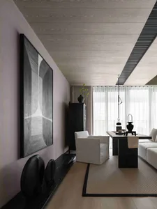 Modern living room featuring wooden flooring, white furniture, and black accents with a large abstract art piece on the wall.