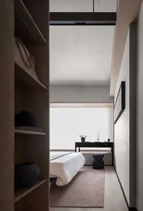 Minimalist bathroom with a white tub, sink, and mirror on a light-colored floor.
