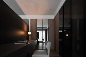 A minimalist home office featuring dark wood surfaces and a sleek, modern design.