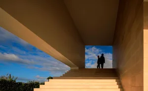 Two people walking up a set of minimalist natural stone stairs in an architecturally designed space.