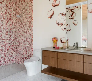 A modern bathroom featuring white ceramic tiles and wooden accents.