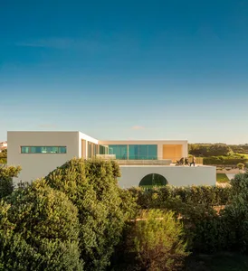 Modern building with large glass windows and outdoor seating area.