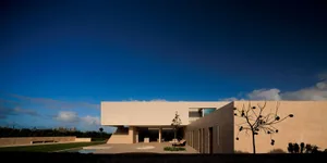 Modern house with concrete and glass exterior illuminated at night