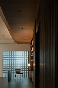 現代工業風辦公空間，搭配玻璃磚牆與深色木質櫥櫃。