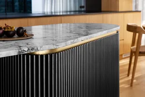 Modern kitchen island featuring a marble top and brass accents.