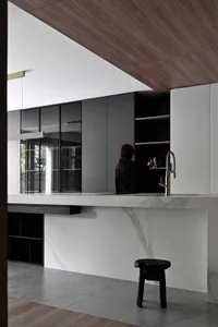 A modern kitchen featuring a white marble countertop and a sleek black faucet.