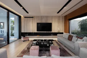 Modern minimalist living room with sleek furniture, wooden walls, and glass windows.