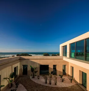 Modern residential exterior with glass walls overlooking the ocean
