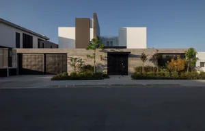 A modern residential exterior featuring concrete and metal materials.