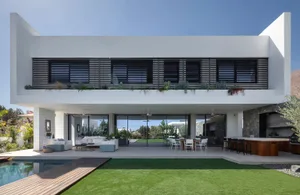 Modern residential space featuring a large patio, swimming pool, and outdoor dining area with a mix of concrete, glass, and w
