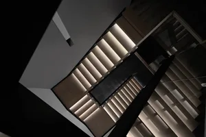 A modern staircase featuring wooden steps and railings, viewed from above.